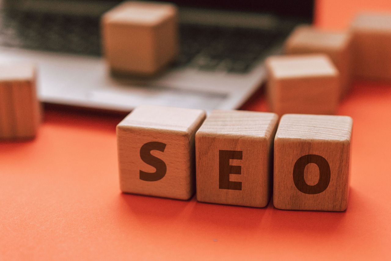 services-02 Wooden blocks spelling SEO on a laptop keyboard convey digital marketing concepts.